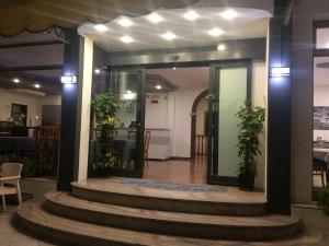een lobby van een gebouw met glazen deuren en potplanten bij Hotel Portofino in Caorle