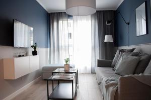 een woonkamer met een bank en een tafel bij NavyBlue apartment Cracow free parking TV in Krakau