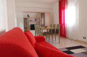 - un salon avec un canapé rouge et une table dans l'établissement Cortile Fichi d'india, à Sciacca