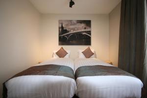 two beds sitting next to each other in a room at Amosa Liège City Centre Apart Regence 17 in Liège