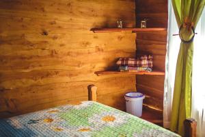 sypialnia z łóżkiem i drewnianą ścianą w obiekcie Ecolodge Rain w mieście Pedregoso