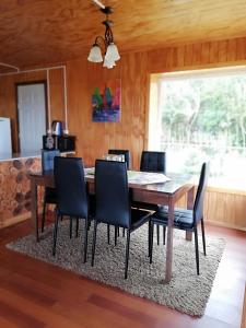 a dining room with a wooden table and chairs at CABAÑA HUALAIHUE AUSTRAL in Hornopiren +56 photos