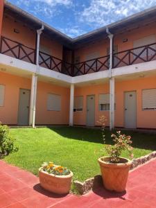 een binnenplaats van een gebouw met twee grote potten bij Hotel Atlántico Residencial in Santa Teresita