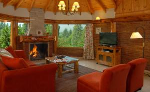 a living room with a fireplace and a television at Villa Escondida in El Hoyo