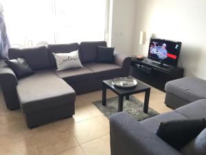 a living room with a couch and a tv at Casa OliCam in Lagos