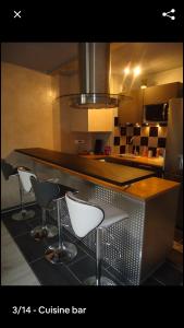eine Küche mit einer Theke mit vier Stühlen in der Unterkunft studio meublé avec balcon in Arcueil