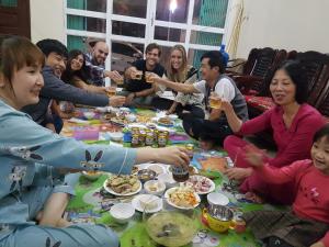 a group of people sitting around a table eating food at Việt Dũng Motel in Ha Long