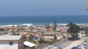 a town with cars parked on a street near the ocean at Miramar El Tabito Depto 302 (6 personas) in El Tabo