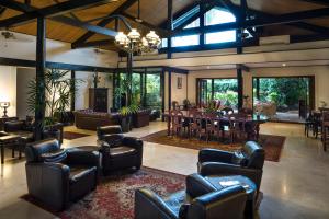 a living room with leather chairs and a dining room at The Fiji Orchid in Lautoka