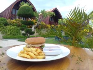 a plate with a sandwich and french fries on a table at Bamboo Bungalow Jungle View in Nusa Penida +42 photos