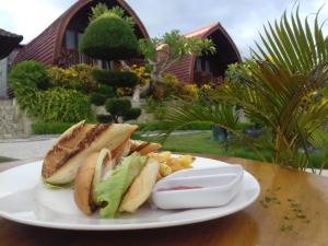 a plate of food with a sandwich on a table at Bamboo Bungalow Jungle View in Nusa Penida