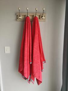 a group of red towels hanging on a rack at The Waterfront Cottage F12 in Swakopmund