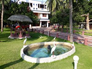 un baño de aves con dos flamencos en un patio en Bekal homestay and resorts, en Bekal