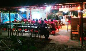 eine Gruppe von Menschen, die nachts in einem Restaurant sitzen in der Unterkunft Emoks Guest House in Moalboal