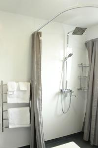 a bathroom with a shower with a mirror and towels at Colonial Motel in Invercargill +51 photos