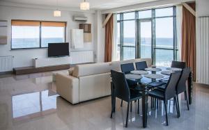 a living room with a table and a couch at Riviera Residence Apartments in Mamaia