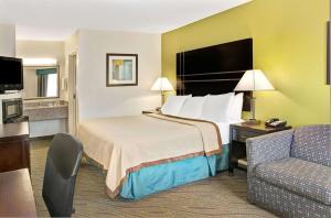 a hotel room with a bed and a couch at Howard Johnson by Wyndham Houston Heights Downtown in Houston