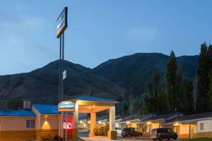 una gasolinera con un cartel en un estacionamiento en Howard Johnson by Wyndham Brigham City, en Brigham City