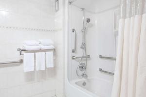 a white bathroom with a shower and a tub at Howard Johnson by Wyndham Newark Airport in Newark +19 photos