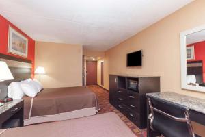 a hotel room with a bed and a television at Howard Johnson by Wyndham Newark Airport in Newark