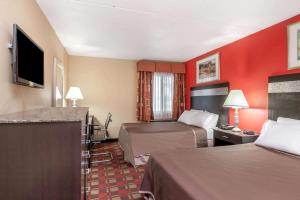 a hotel room with two beds and a flat screen tv at Howard Johnson by Wyndham Newark Airport in Newark