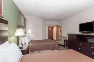 a hotel room with a bed and a flat screen tv at Howard Johnson by Wyndham Newark Airport in Newark