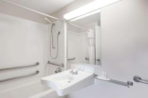 Baño blanco con lavabo y espejo en Howard Johnson by Wyndham Lenox en Lenox