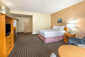 a hotel room with a bed and a television at Howard Johnson by Wyndham Tillsonburg in Tillsonburg