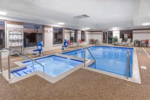 a large swimming pool in a hotel room at Wingate by Wyndham Joliet in Joliet