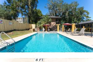 a swimming pool in a yard with chairs and a fence at Howard Johnson by Wyndham Tallahassee in Tallahassee