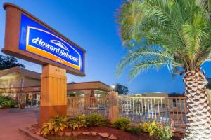 un cartel frente a un centro comercial con una palmera en Howard Johnson by Wyndham Historic Lake Charles, en Lake Charles