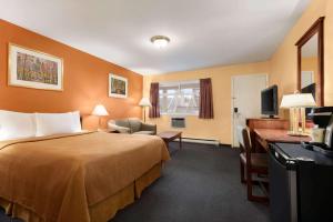 Pokój hotelowy z łóżkiem i biurkiem w obiekcie Travelodge by Wyndham Quesnel BC w mieście Quesnel
