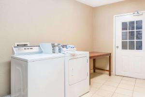 a washer and dryer in a room with a table at Howard Johnson by Wyndham Historic Lake Charles in Lake Charles