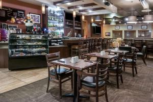 a restaurant with tables and chairs and a bakery at Stony Plain Inn & Suites in Stony Plain