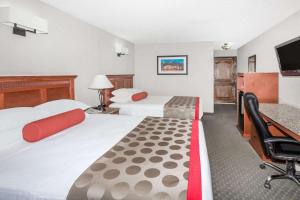 a hotel room with two beds and a desk at Ramada by Wyndham Frisco in Frisco