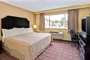 a hotel room with a bed and a television at Howard Johnson by Wyndham Pikesville in Pikesville