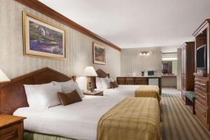 Кровать или кровати в номере Ramada by Wyndham Saginaw Hotel & Suites