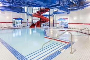 - une piscine avec toboggan rouge dans l'établissement Ramada by Wyndham Westlock, à Westlock