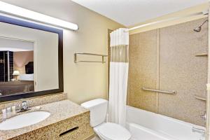 a bathroom with a toilet and a sink and a shower at Howard Johnson by Wyndham Pikesville in Pikesville