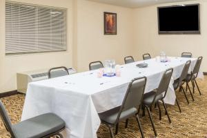 Microtel Inn & Suites by Wyndham Uncasville Casino Area في أنكاسفيل: قاعة اجتماعات مع طاولة بيضاء كبيرة وكراسي