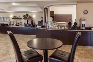 un restaurant avec une table, des chaises et un comptoir dans l'établissement Ramada by Wyndham Westlock, à Westlock