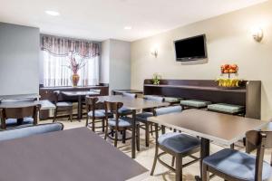 a restaurant with tables and chairs and a tv at Microtel Inn Georgetown - Lexington North in Georgetown