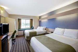 Rúm í herbergi á Microtel Inn & Suites by Wyndham Statesville