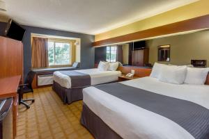 a hotel room with two beds and a desk at Microtel Inn & Suites by Wyndham Hillsborough in Hillsborough +18 photos
