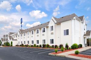 a large white building with a parking lot at Microtel Inn and Suites Clarksville in Clarksville