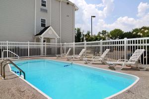 una piscina con sillas y una valla blanca en Microtel Inn & Suites Huntsville, en Huntsville