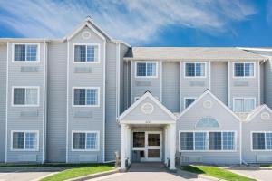 a large house with white siding at Microtel Inn & Suites by Wyndham New Ulm in New Ulm