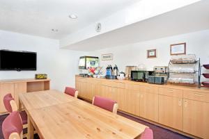 a conference room with a table and a kitchen at Microtel Inn & Suites, Morgan Hill in Morgan Hill