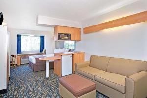 a small hotel room with a couch and a bed at Microtel Inn & Suites, Morgan Hill in Morgan Hill
