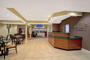 a large lobby with tables and chairs and a restaurant at Microtel Inn & Suites by Wyndham Bushnell in Bushnell